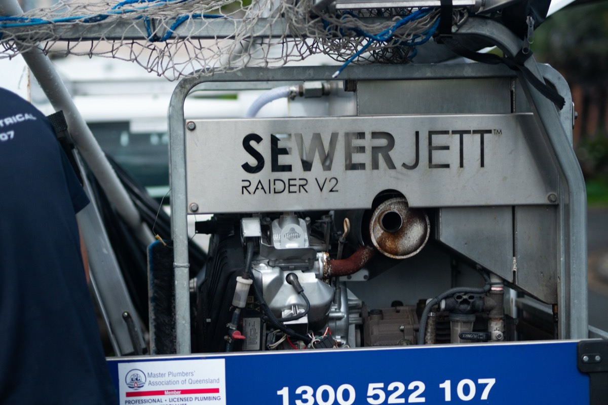 The Moral Service jet rodding rig on the back of the ute, with the MPAQ member badge and 1300 522 107 on the frame